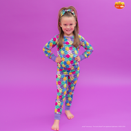 Child wearing a colorful emoji-themed onesie on a purple background