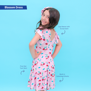 Girl wearing a Smurfs pink dress with floral patterns on a blue background