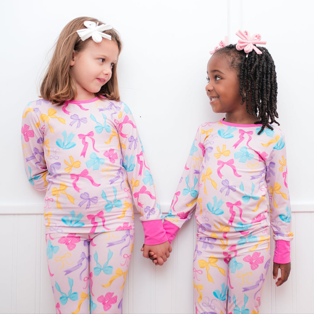 Two children wearing colorful pajamas with butterfly patterns against a white background.