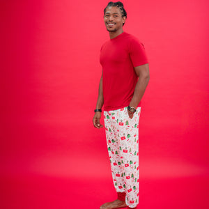 Man wearing a red t-shirt and patterned pajama pants on a red background