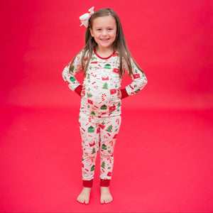 Child wearing a festive pajama set on a red background