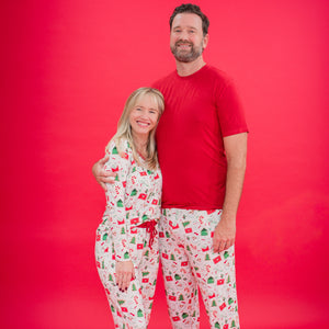 Two people wearing matching pajamas against a red background