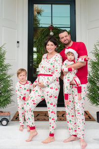 Family of four wearing matching pajamas in front of a house entrance.
