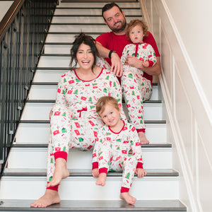 Family of four in matching pajamas sitting on a staircase
