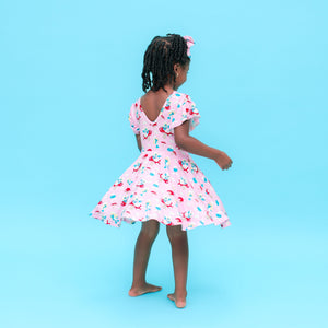 Young girl in a Smurfs pink dress with white patterns on a blue background